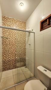 uma casa de banho com uma cabina de duche em vidro e um WC. em Pousada Vila Cajuína - Parnaíba na Parnaíba