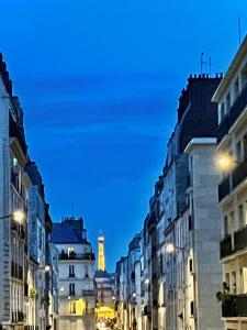 a city street at night with a clock tower in the distance w obiekcie Appartement élégant - 2 chambres - 2 salles de bain w Paryżu