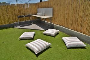 three pillows on the grass in front of a fence at וילה על ההר - וילה כפרית למשפחות עם בריכה פרטית in Poriyya
