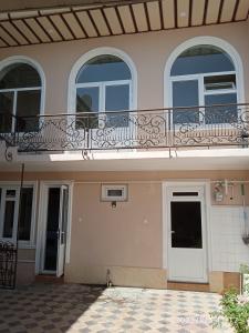 um edifício com uma varanda e duas janelas em Гостевой дом AL XALIL em Samarkand