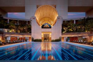 uma piscina em frente a um edifício em The Ritz-Carlton, Millenia Singapore em Singapura