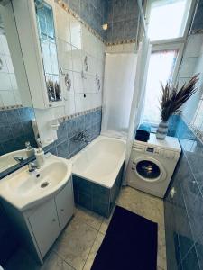 a bathroom with a sink and a washing machine at Sailor Apartment by Marina Old Town for 8 people, free parking! in Gdańsk