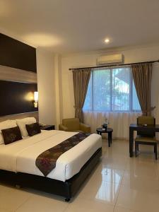 a hotel room with a large bed and a chair at aresidencia sei putih in Medan
