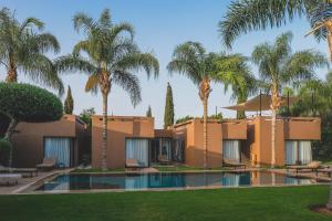 馬拉喀什的住宿－VILLA STANISLAS GOLF RESORT AL MAADEN，棕榈树和游泳池度假村