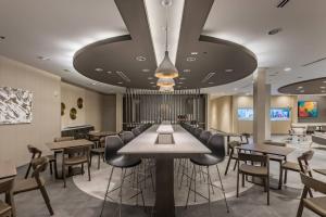 um restaurante com mesas e bancos numa sala em SpringHill Suites by Marriott Dallas Rockwall em Rockwall