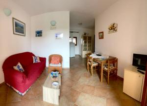 a living room with a red couch and a table at Casa Debili in San Teodoro