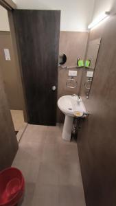 HOTEL INDIANA في شيلونغ: حمام مع حوض أبيض ومرآة