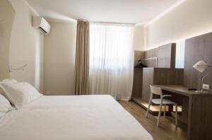 帕多瓦的住宿－M14 Hotel & Spa，配有一张床和一张书桌的酒店客房