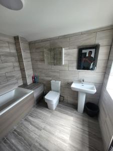 a bathroom with a sink and a toilet and a bath tub at The Goldmine Rooms in Hale