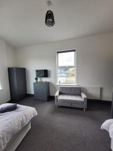 a bedroom with a bed and a couch and a window at The Goldmine Rooms in Hale