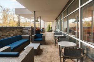 un restaurante con sofás azules, mesas y ventanas en SpringHill Suites by Marriott Somerset Franklin Township en Somerset