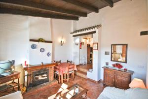 sala de estar con sofá y chimenea en Cortijo Las Monjas, en Periana