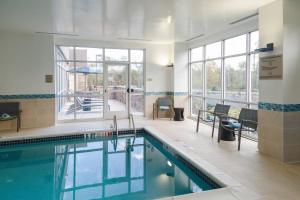 a swimming pool in a building with a large window at SpringHill Suites by Marriott Somerset Franklin Township in Somerset