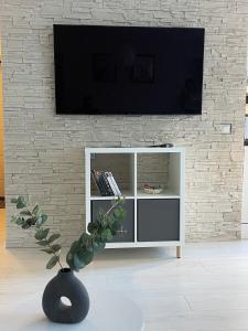 a living room with a tv on a brick wall at New Modern Apartments in the City Center in Narva