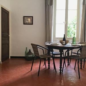 uma sala de jantar com uma mesa e cadeiras e uma janela em La Demeure du Pont Vieux em Collobrières