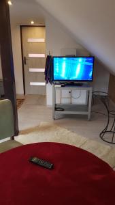 sala de estar con TV y mando a distancia en Turystyczny apartament na poddaszu, en Skoczów