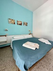 Habitación azul con cama y toallas. en Hotel Sylva, en Cattolica