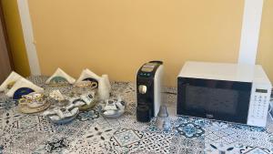 a counter top with a microwave and a computer on it at U Curtigliu apartment in Realmonte