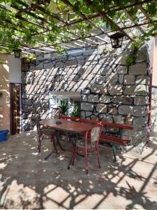 a picnic table and chairs in front of a stone wall at Apart Hotel Hetodon in Sozopol