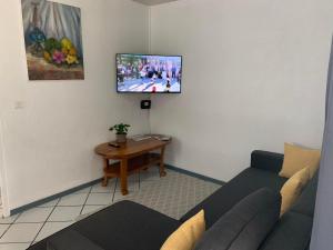 a living room with a couch and a tv on the wall at Fare Manatea 19 in Papeete