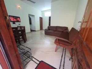 uma sala de estar com um sofá e uma mesa em The Nest Lovely 3BHK and 1BHK Villa em Chennai