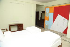 a bedroom with two beds and a painting on the wall at The Nest Lovely 3BHK and 1BHK Villa in Chennai