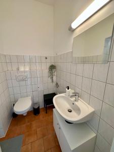 a white bathroom with a sink and a toilet at Kröpi 8 in Bad Doberan