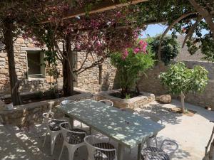 a table and chairs in a patio with flowers at Mandri B&B in Serifos Chora
