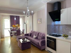 sala de estar con sofá púrpura y mesa en Studio Apartment, en Baku