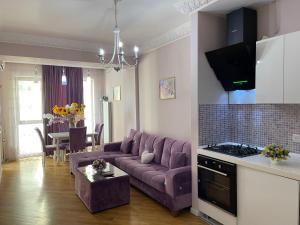 a living room with a purple couch and a table at Studio Apartment by Bakuapart in Baku