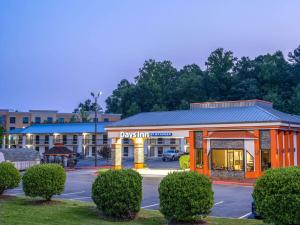 un hôtel avec un parking en face d'un bâtiment dans l'établissement Days Inn by Wyndham Clemson, à Clemson