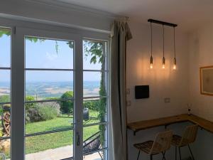 Habitación con ventana, mesa y sillas en Casale Osvalda, en Alfiano Natta