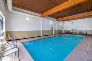 een groot zwembad in een gebouw met een houten plafond bij Wingate by Wyndham Butte City Center in Butte