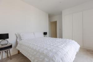 a white bedroom with a white bed and a desk at Dockside Apartment With Scenic Views in London