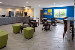 a restaurant with tables and chairs and a bar at Days Inn by Wyndham Louisburg in Louisburg