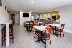 a restaurant with tables and chairs and a kitchen at Days Inn by Wyndham Louisburg in Louisburg