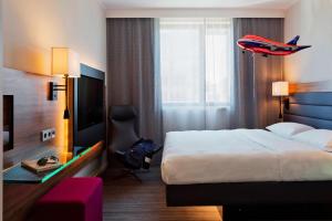 a hotel room with a bed and a television at MOXY Vienna Airport in Schwechat