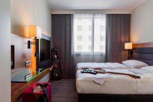 ein Hotelzimmer mit 2 Einzelbetten und einer Gitarre in der Unterkunft MOXY Vienna Airport in Schwechat