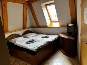 a small bed in a room with a window at Penzión Alberto in Prievidza