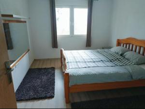 a bedroom with a bed and a window and a rug at Sunnyhill in Sarajevo