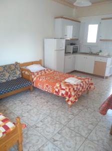 a room with two beds and a couch and a kitchen at Kouzelis apartments in Kanatádhika