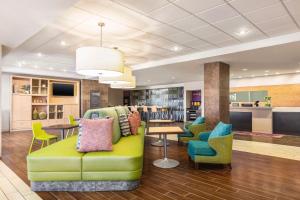 Home2 Suites by Hilton Lubbock في لوبوك: لوبي فيه اريكه خضراء وكراسي