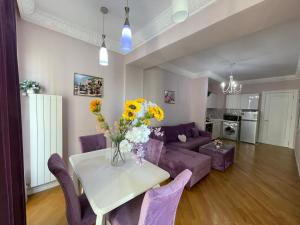 a living room with a purple couch and a table with flowers at Studio Apartment in Baku