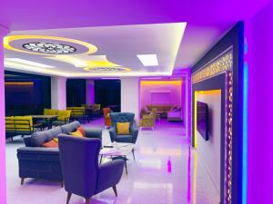 un soggiorno con sedie e tavoli viola e giallo di Z&A kılıç apart otel a Kerburun