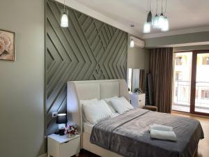 a bedroom with a bed with a large wooden headboard at Studio Apartment in Baku