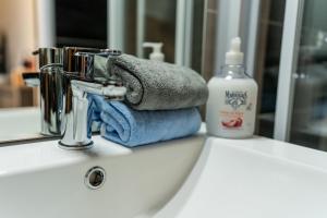 un lavandino del bagno con un asciugamano e uno specchio di Le Charentais #Confort #RDC a Cognac Altre 15 foto