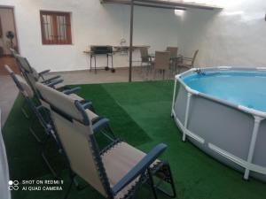 a room with a pool and chairs and a table at Cortijocueva con encanto natural in Terque