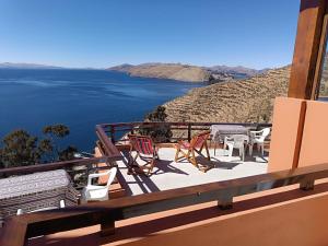 a balcony with chairs and a view of the water at Sol y Luna - ISLA DEL SOL Bolivia in Comunidad Yumani