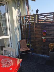 a patio with a chair and a table and a cat at Apartament Woda Morska in Ustka