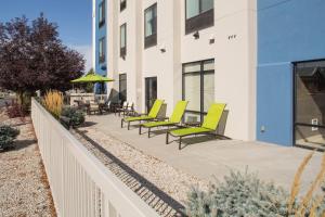 a row of yellow chairs on a patio next to a building at SpringHill Suites by Marriott Billings in Billings